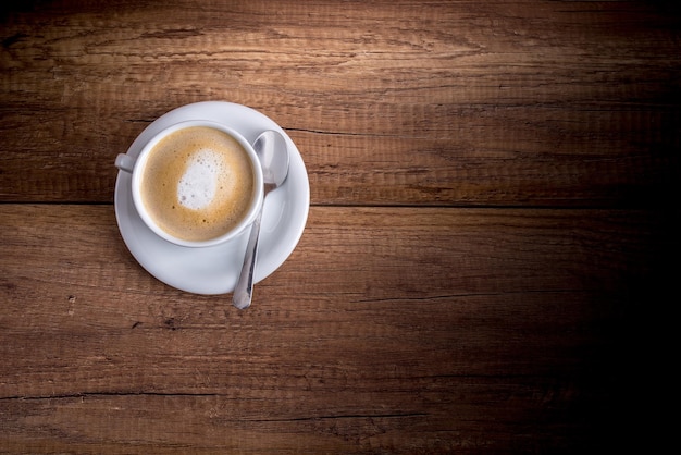 Foto una tazza di cappuccino aromatico appena preparato su un tavolo di legno