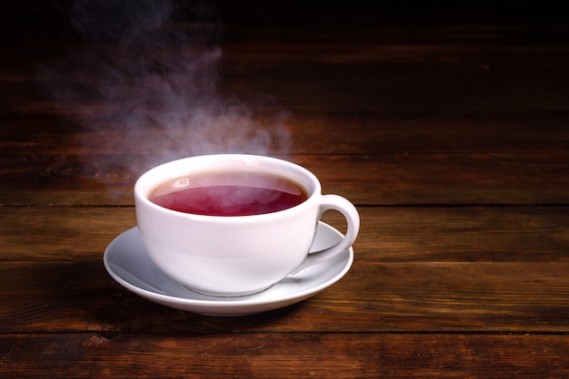 Photo a cup of freshly brewed black tea,escaping steam,warm soft light