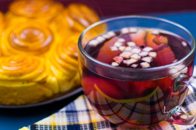 A cup of fruit tea on the background of homemade cakes