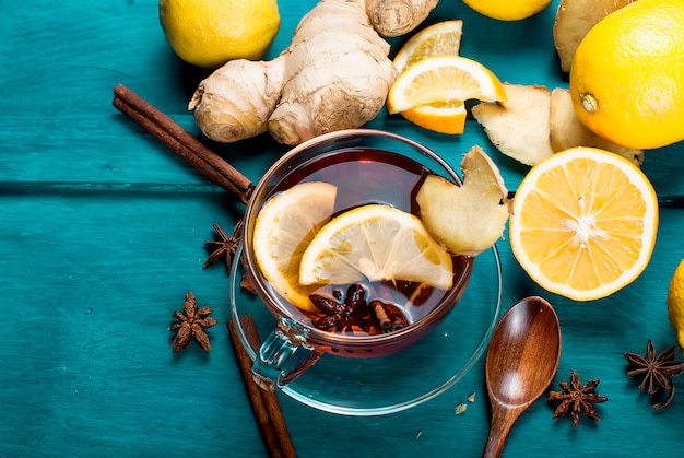 Cup of Ginger tea with lemon and honey on dark blue,