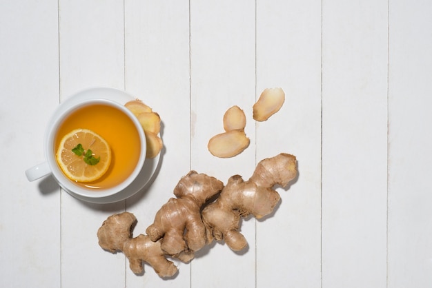 Cup of Ginger Tea with Lemon and Honey on a White Wooden Background.