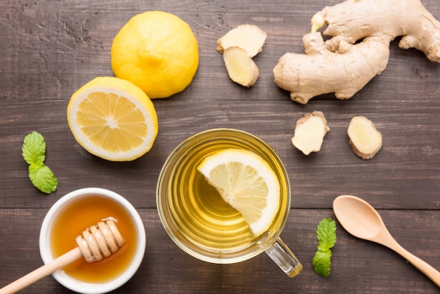 Cup of ginger tea with lemon and honey on wooden table