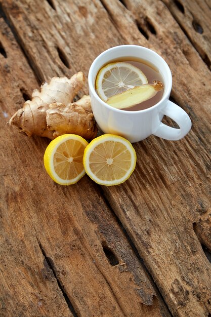 Foto tazza di tè allo zenzero con limone su legno