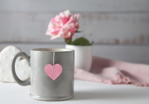 A cup, gingerbread in the form of hearts and a white-pink rose. Romance and Valentine's Day