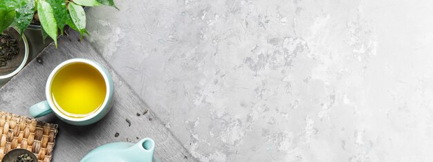 A cup of green tea in a blue cup on a gray concrete background