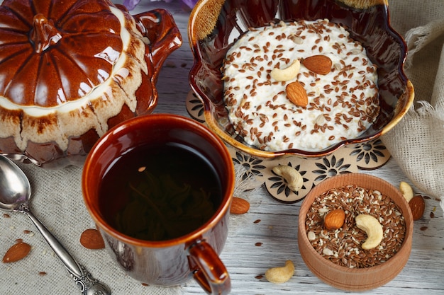 一杯の緑茶、カッテージチーズとオート麦フレーク、亜麻仁、ナッツ、蜂蜜