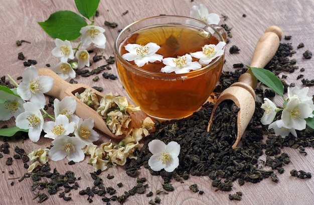 cup of green tea with jasmine on a wooden table.