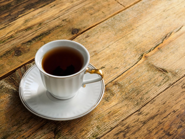 A Cup of herbal tea on an old worn Board