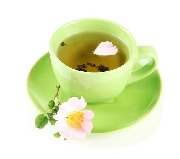 Cup of herbal tea with hip rose flower isolated on white