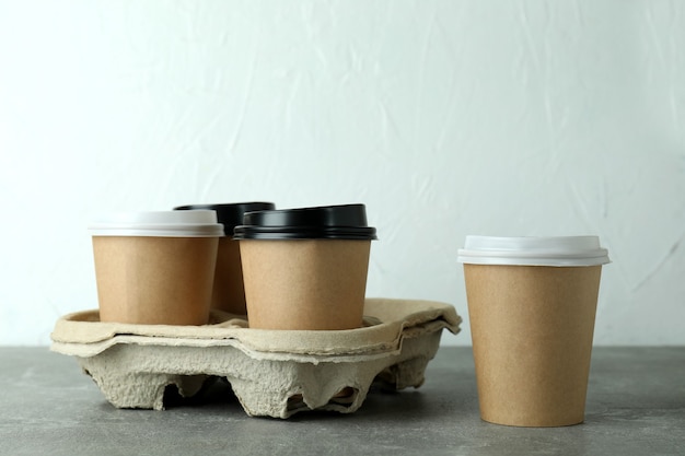 Cup holder with coffee cups on gray textured table