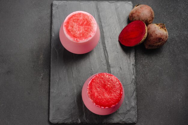 A cup of hot beet coffee latte on a light wooden background a trendy healthy drink