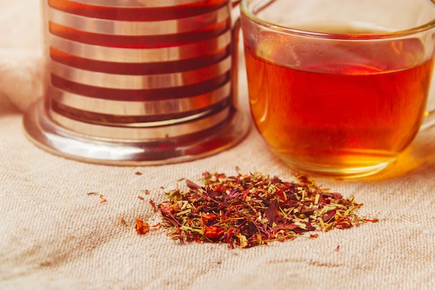 Cup of hot black tea, dried tea leaves