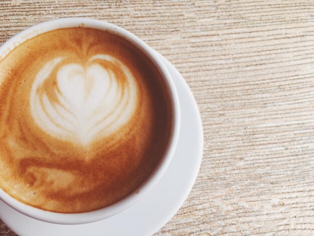 Tazza di cappuccino caldo in una caffetteria caffè su un tavolo di legno nella caffetteria