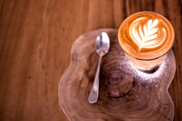 La tazza di cappuccino caldo è sul tavolo di legno