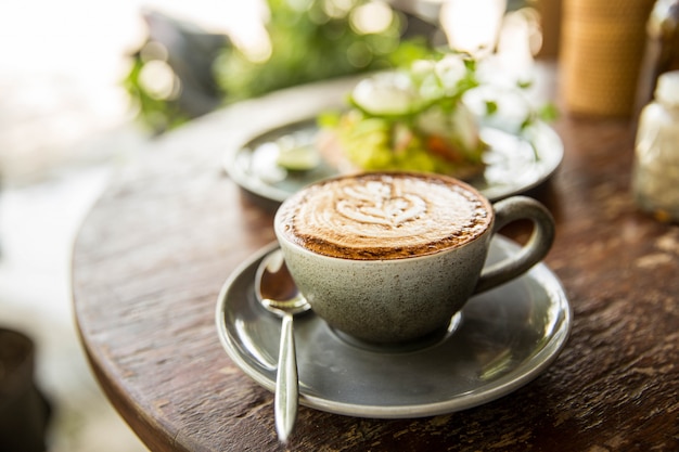 木製のテーブルでホットカプチーノカップ