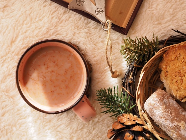 Cup of hot chocolate cookies and fir branches on a white fluffy background