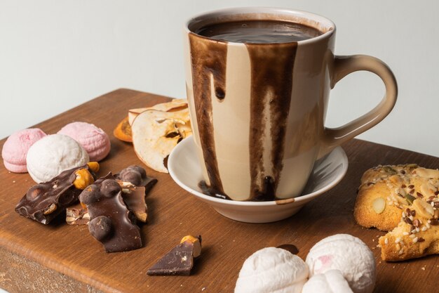 Cup of hot chocolate and marshmallows, and pieces of chocolate.