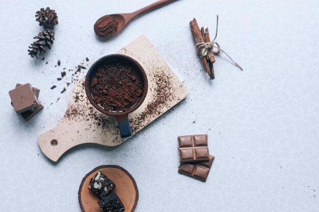 Cup of hot chocolate and pieces of chocolate on white background