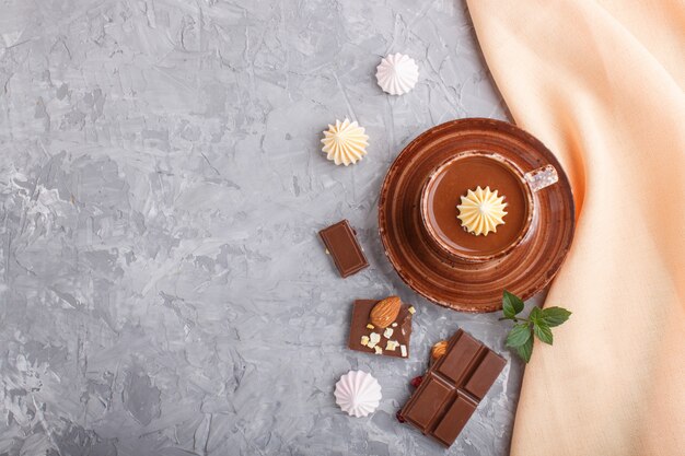 Tazza di cioccolata calda e pezzi di cioccolato al latte con mandorle