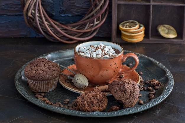 Una tazza di cioccolata calda con marshmallow e muffin da vicino