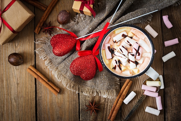 Cup of hot cocoa or chocolate with marshmallow on  wooden background