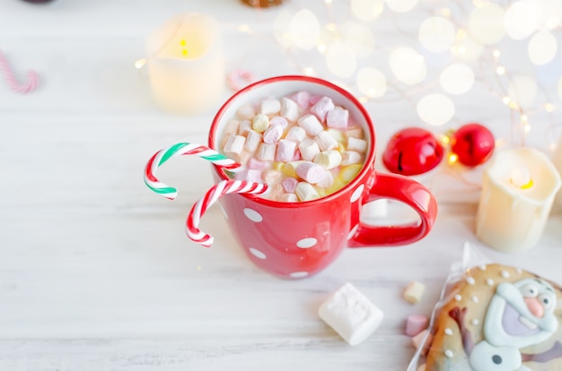 Cup of hot cocoa with beautiful traditional sugar glazed christmas gingerbread cookies