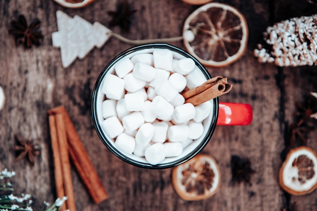 Una tazza di cioccolata calda con marshmallow e cannella in una cornice di capodanno. vista dall'alto.