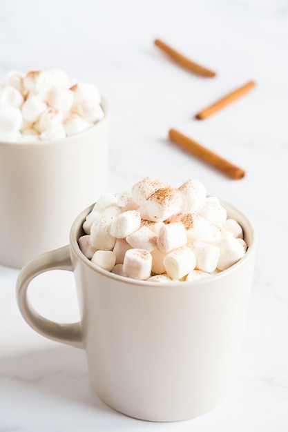 Cup of hot cocoa with marshmallows on white table