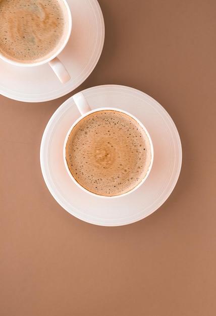 Cup of hot coffee as breakfast drink flatlay cups on beige background