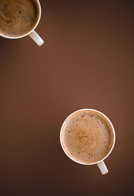 Cup of hot coffee as breakfast drink flatlay cups on brown background