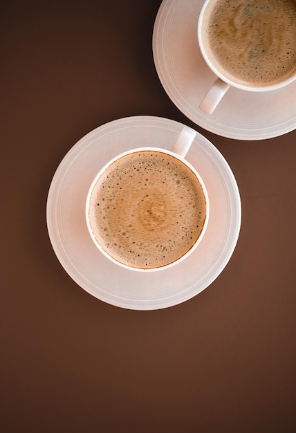 Cup of hot coffee as breakfast drink flatlay cups on brown background