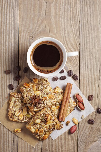 Чашка горячего кофе и печенье с орехами на старом деревянном столе, вид сверху