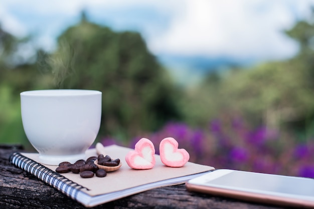 cup of hot coffee for morning drink with sweet heart candy. relax and freedom with natural background. Copy space for text