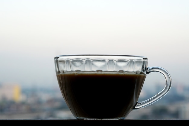 高層ビルの窓枠で朝のホットコーヒー一杯