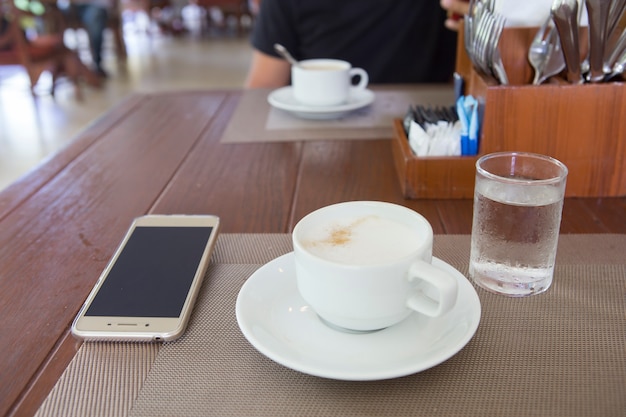 朝のテーブルでホットコーヒーのカップ。