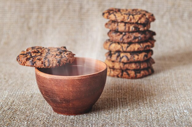 ホットコーヒーまたは紅茶とテーブルの上のおいしい甘いクッキーのカップ