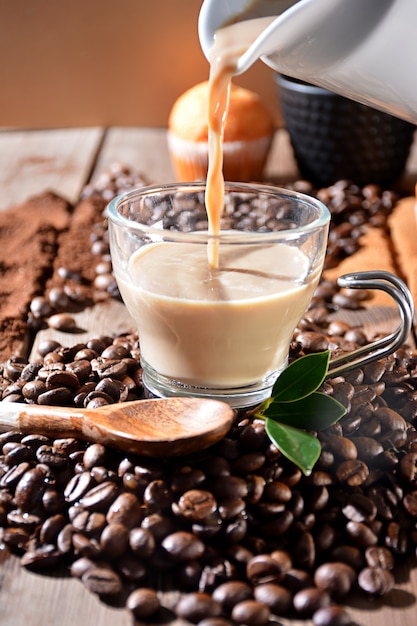 Cup of hot coffee with muffins, coffee beans and cinnamon