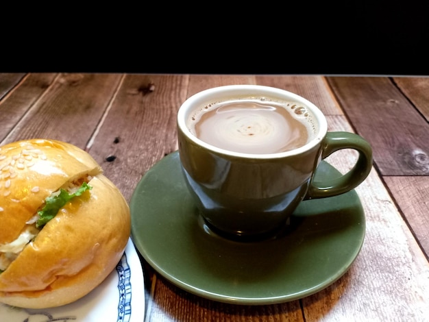 A cup of hot coffee with tuna burgers.