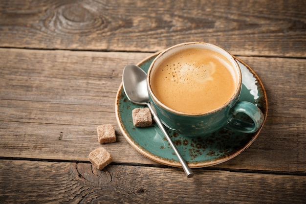 Чашка горячего кофе на деревянном столе