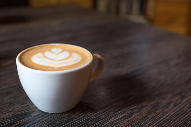 Cup of hot coffee on a wooden table