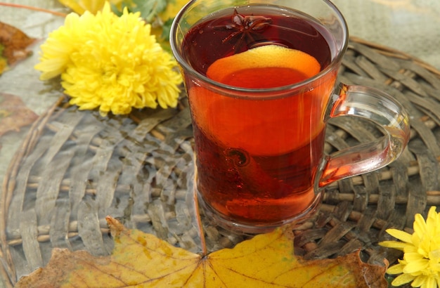 Cup of hot drink and autumn leaves close up