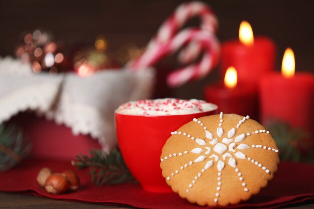 Cup of hot drink and Christmas cookie on table