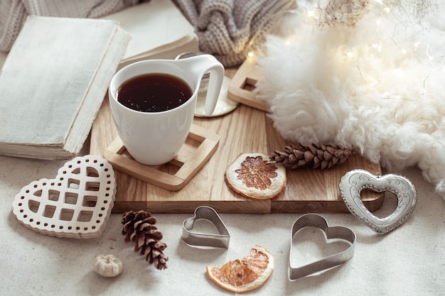 A cup of hot drink and cute home decor items. The concept of home comfort and aesthetics.