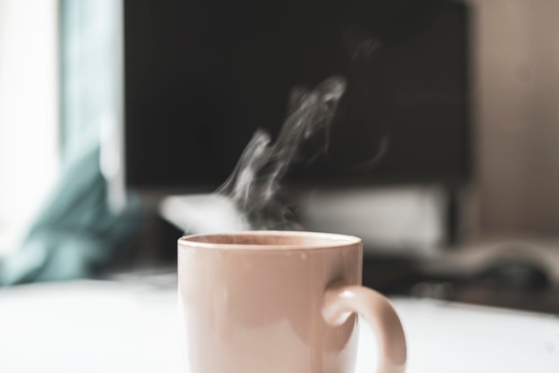 A cup of hot drink on the table with aromatic steam