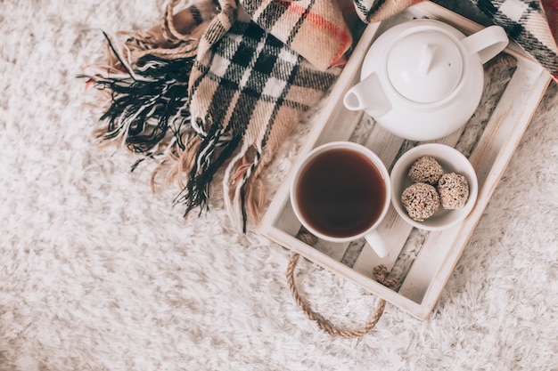 Cup of hot drink and teapot on a serving tray