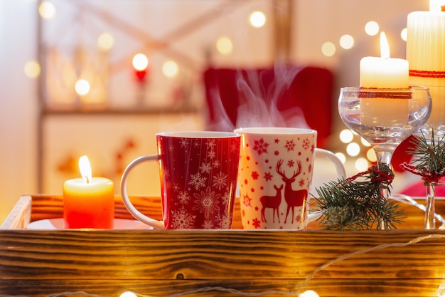 Cup of hot drink with christmas decorations in white and red colors at home