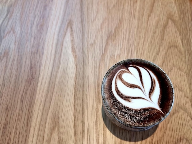 A cup of hot latte art chocolate or hot cocoa on wooden background