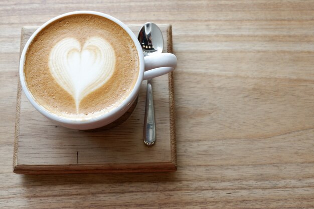 A cup of hot latte art coffee on table