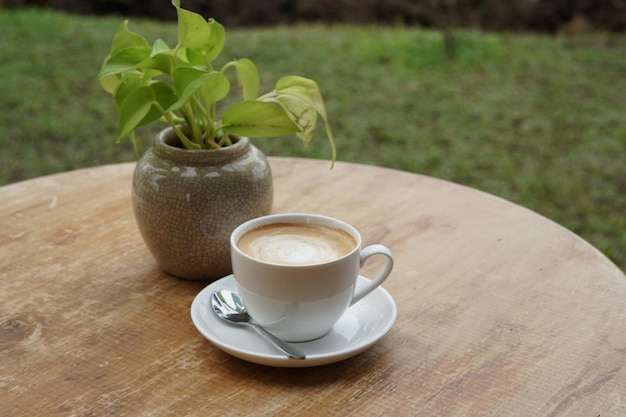 木製のテーブルの上のホットラテコーヒーのカップ