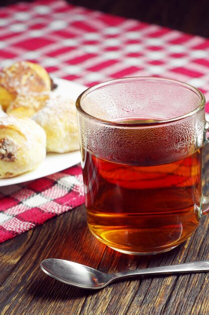 Cup of hot tea and cookies wit raisins on rustic table